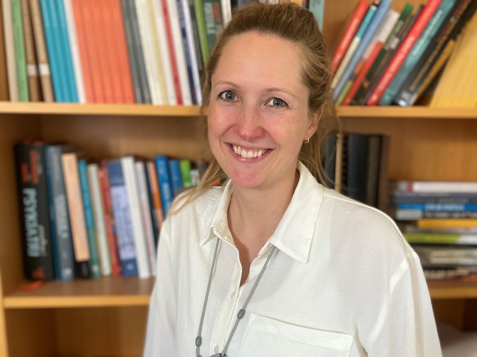 Camilla foran bogreol på kontoret